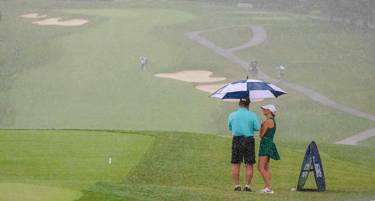Spectators stand under umbrella at second round of 2025 WPGA Open Championship at Sewickley Heights Golf Club Spectators stand under umbrella at second round of 2025 WPGA Open Championship at Sewickley Heights Golf Club